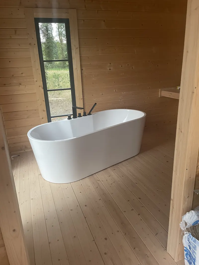 La baignoire îlot devant la baie vitrée